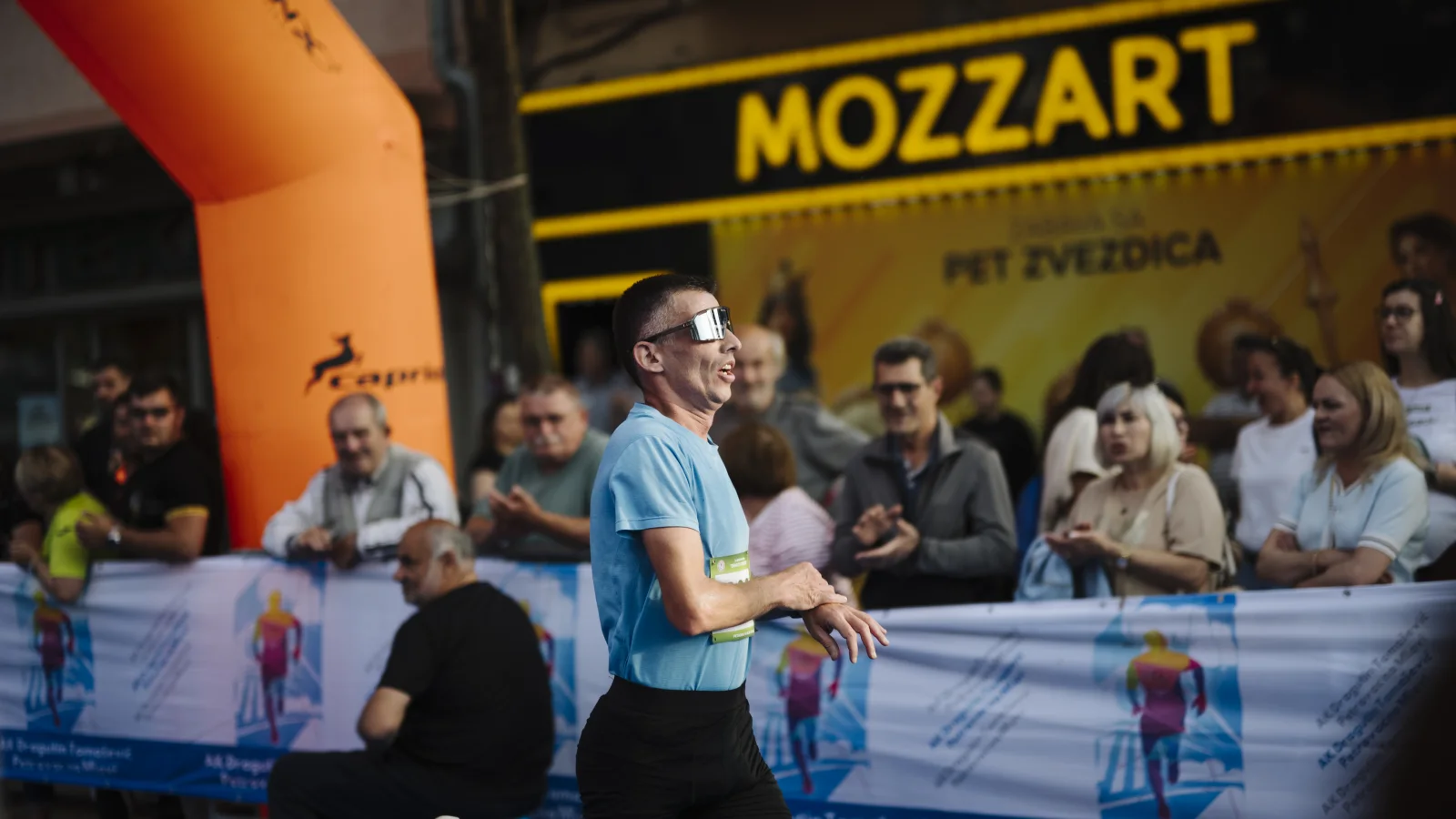 Runners competing on a city street while spectators cheer from both sides of the road